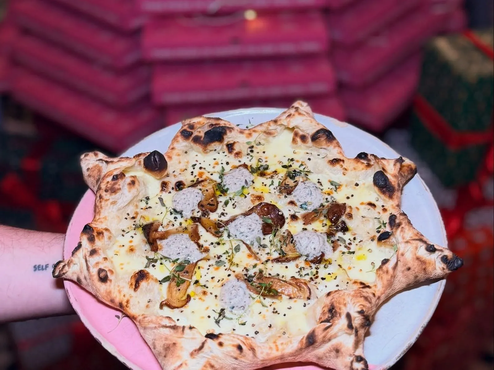 Charakterystyczne różowe pudełka Marcello na pizzę na wynos